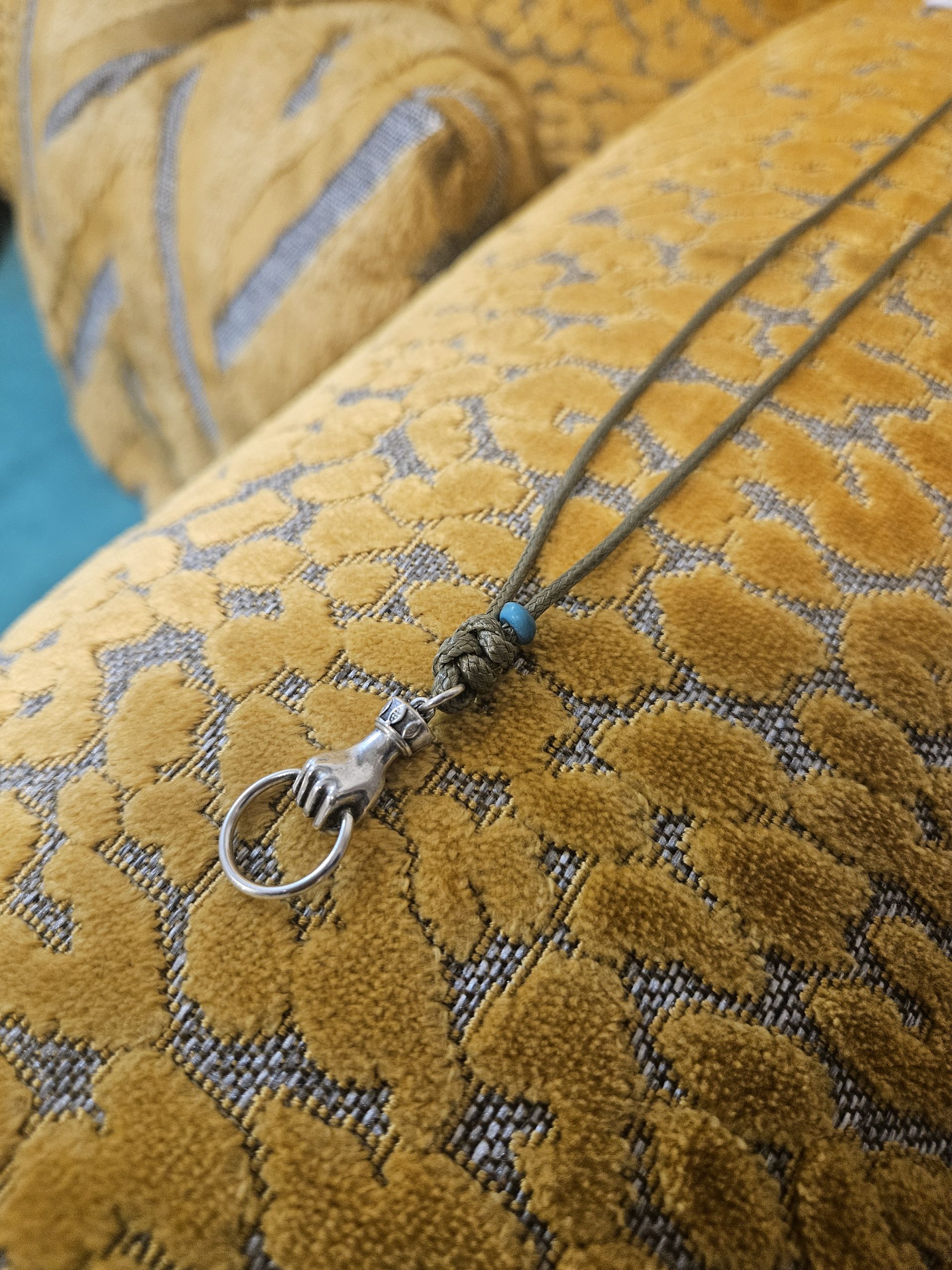 halskette-silberne-faust-mit-ring-olivgruenes-band Halskette mit Glückshand und Ring